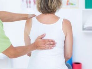 Un paciente con queixas de dor nas costas na zona dos omóplatos está sendo examinado por un médico